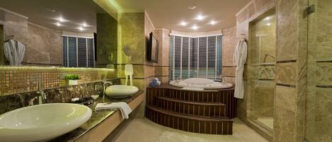 A modern bathroom with a large sink, a bathtub, and a walk-in shower.