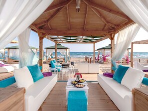 Playa privada, camas de playa (con cargo), camastros y sombrillas