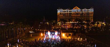 A large hotel with a grand facade and a crowd gathered in front.