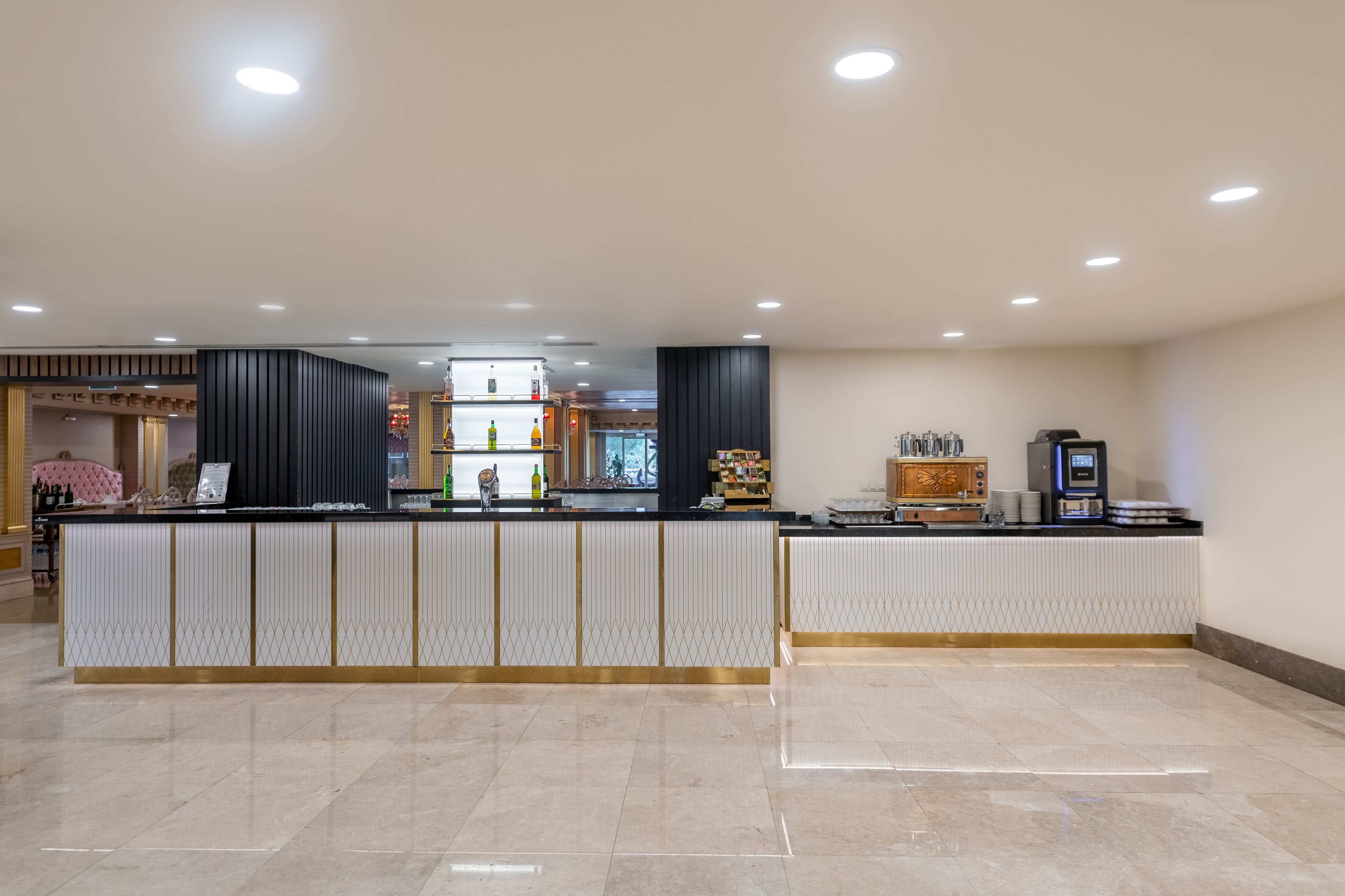 A modern reception area with a counter, seating, and a coffee machine.