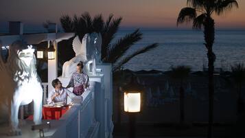 A couple dining at a table with a view of the ocean.