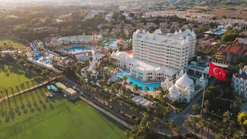 Experience the grandeur of this luxurious hotel, featuring a large pool area surrounded by palm trees and leisure facilities.