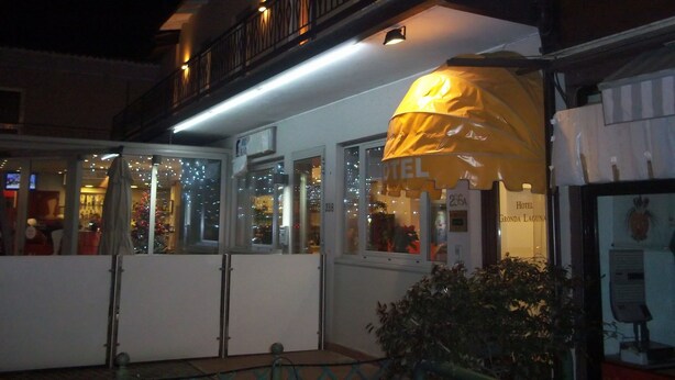 A hotel with a balcony, large windows, and a sign indicating it is a hotel.