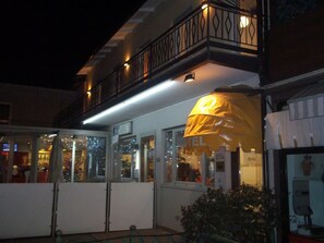 Un hotel con balcón, ventanas amplias y un cartel que indica que es un hotel.