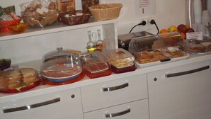 A buffet with various food items including sandwiches, fruits, and desserts.