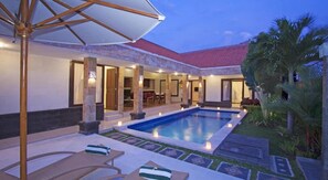 A poolside area with a pool, lounge chairs, and a covered seating area. - Bali Asih Villa (Kerobokan)