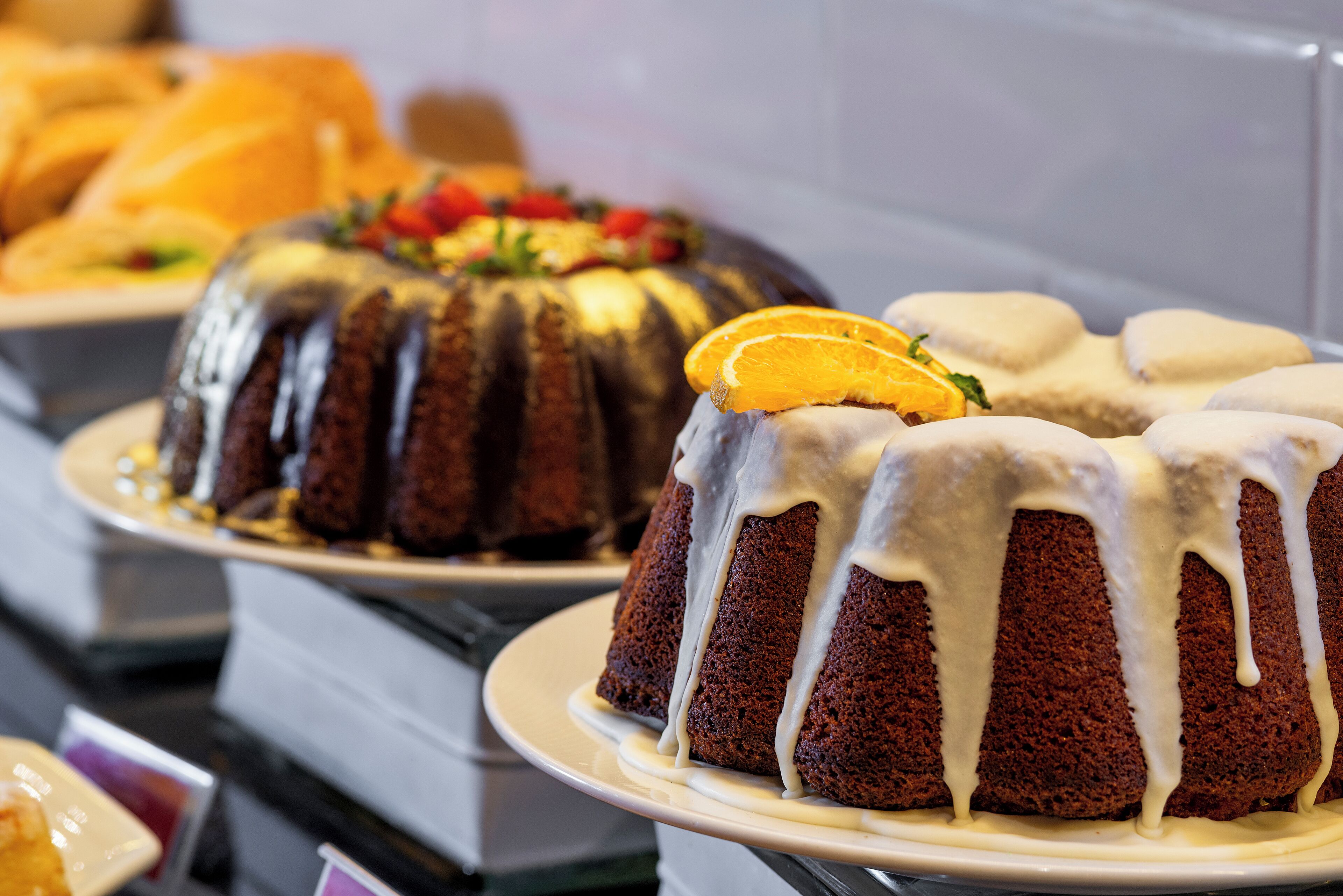 A cake with white icing and orange slices on a plate.