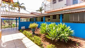 A courtyard with a tiled floor, a blue wall, and a building with a satellite dish. - Pousada das Estrelas Atibaia (Atibaia)