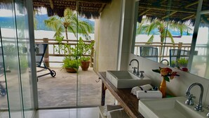 Un baño con dos lavamanos, un espejo y vistas a la playa.