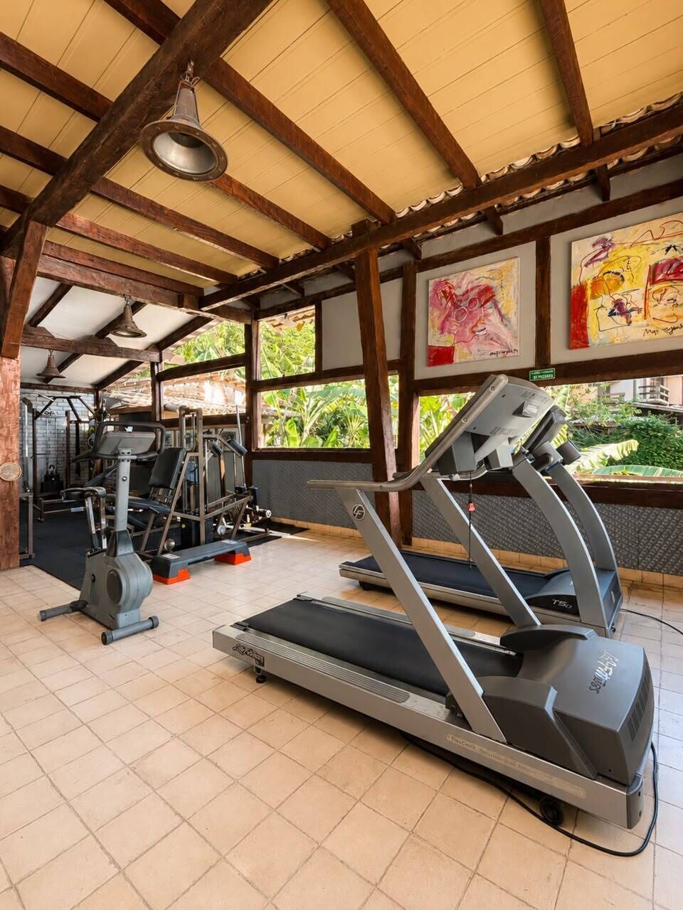 A gym with treadmills, weight machines, and exercise mats.