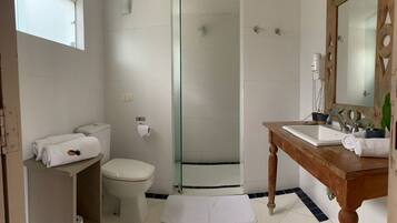 A bathroom with a toilet, sink, and shower.