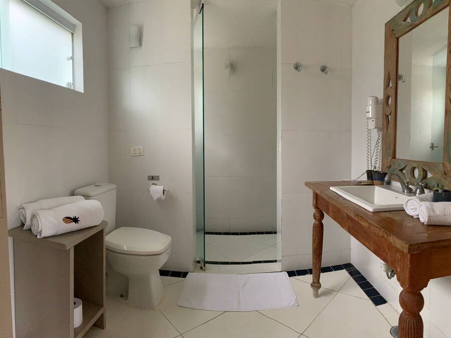 A bathroom with a toilet, sink, and shower.