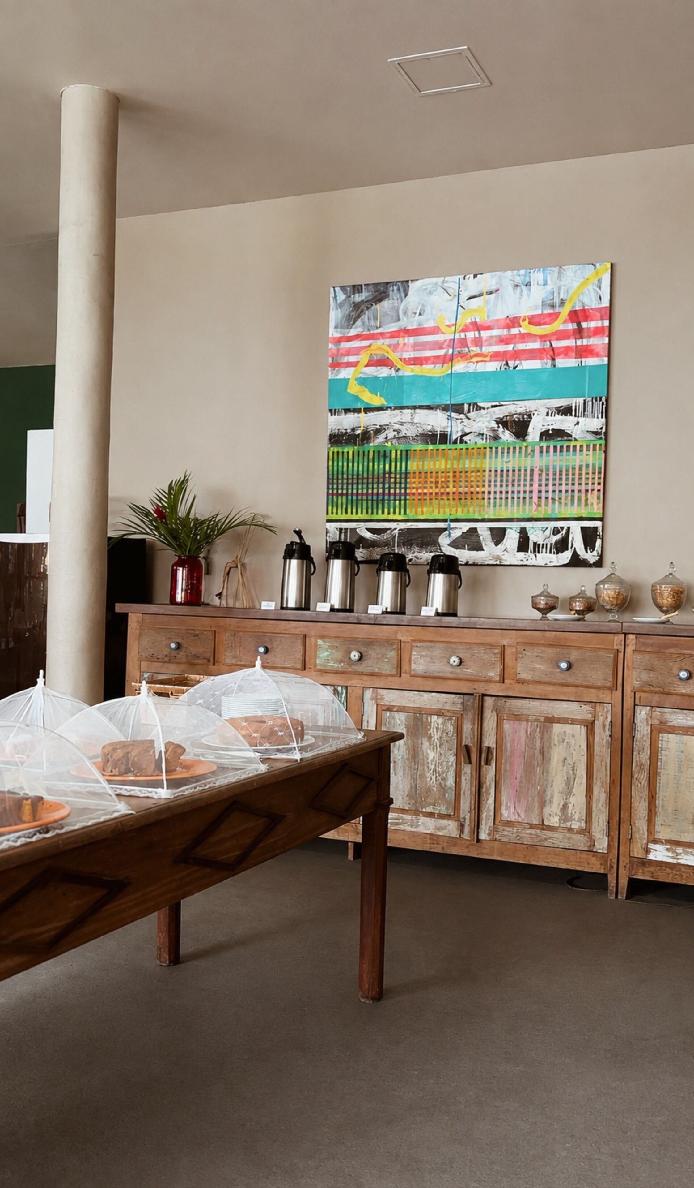 Una habitación con un armario de madera, un cuadro y una cama.