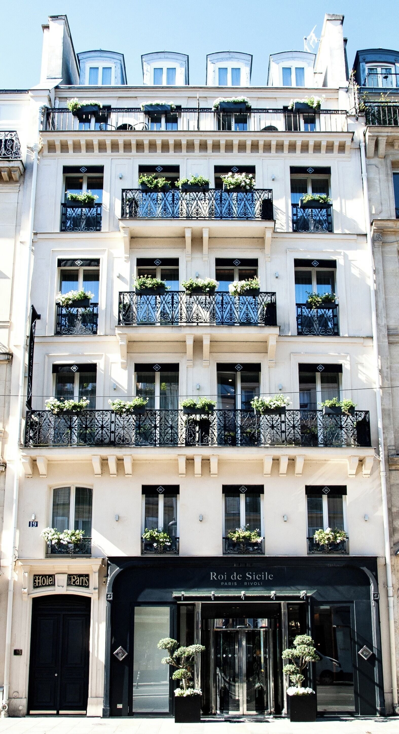 A multi-story hotel with balconies, a black entrance, and a sign reading "Roi de Sicile Paris".