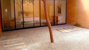 Un edificio moderno con fachada de vidrio, patio de grava y terraza de madera.