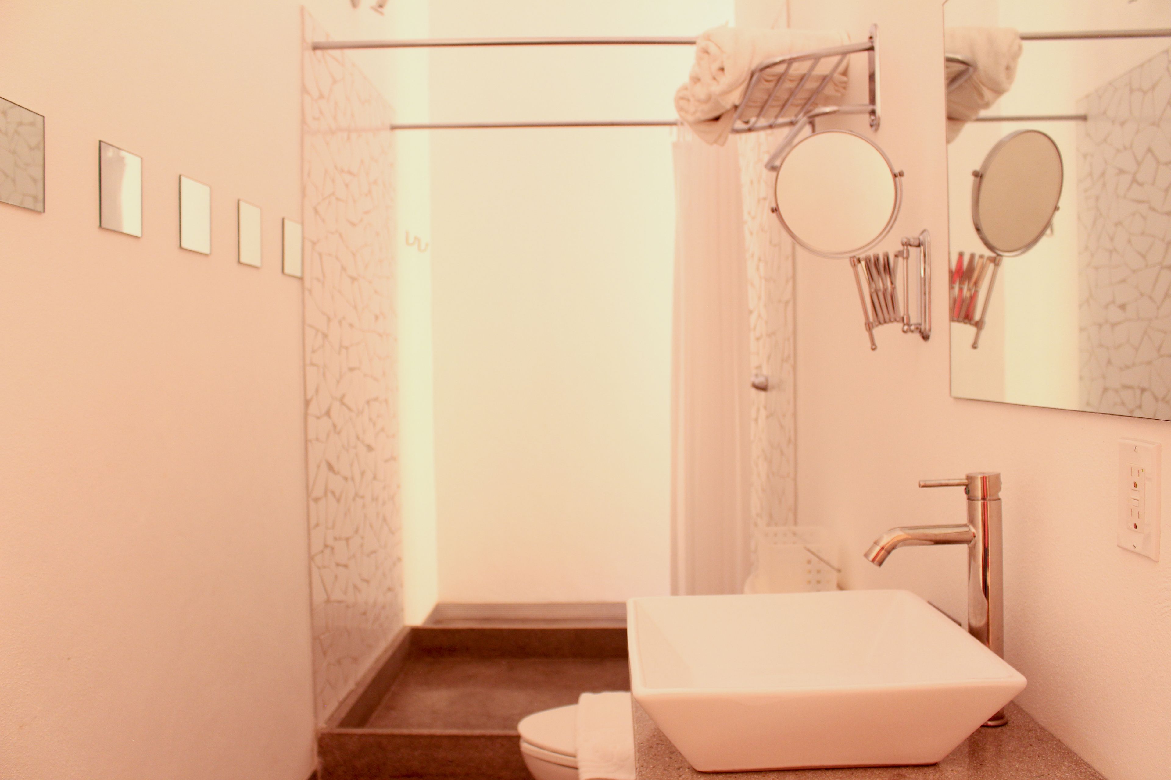 Un baño con lavamanos blanco, inodoro y zona de ducha.