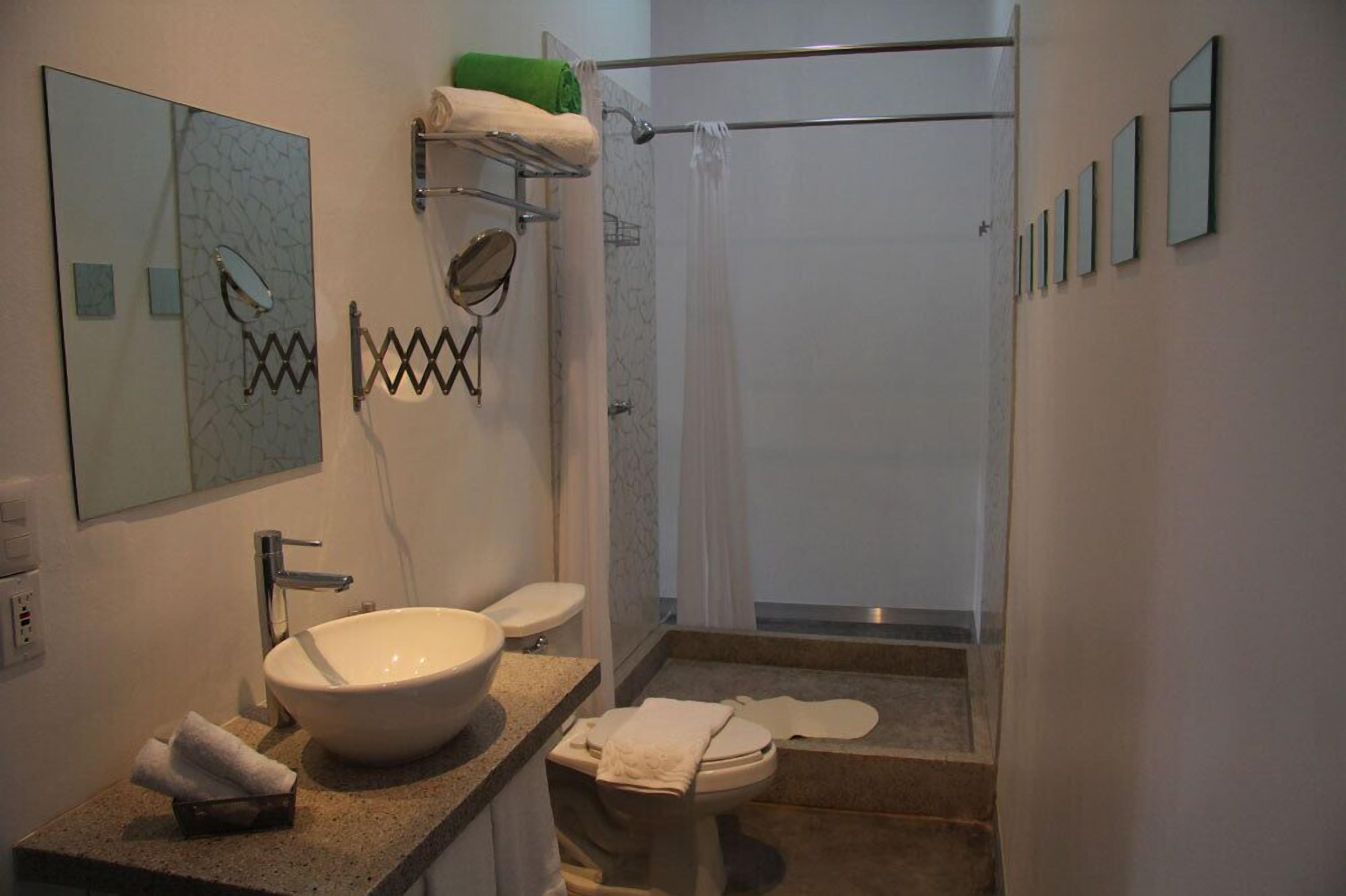 Een badkamer met een groot wastafel, toilet en douche.