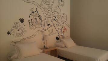 Ein Zimmer mit zwei Betten, einem Nachttisch und einer Wand mit Wandgemälde.