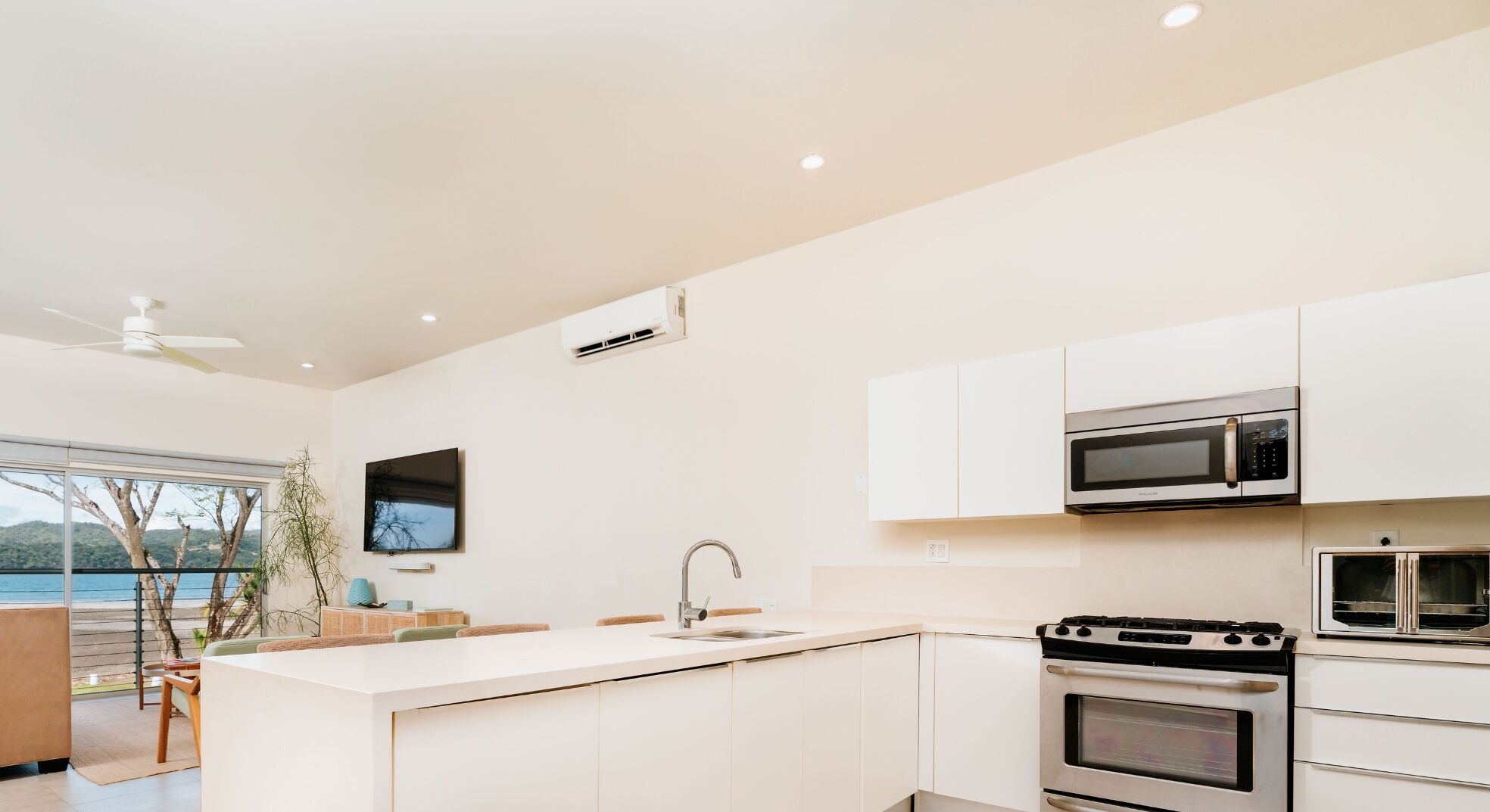 Una cocina moderna con una isla grande, electrodomésticos de acero inoxidable y vistas al mar.