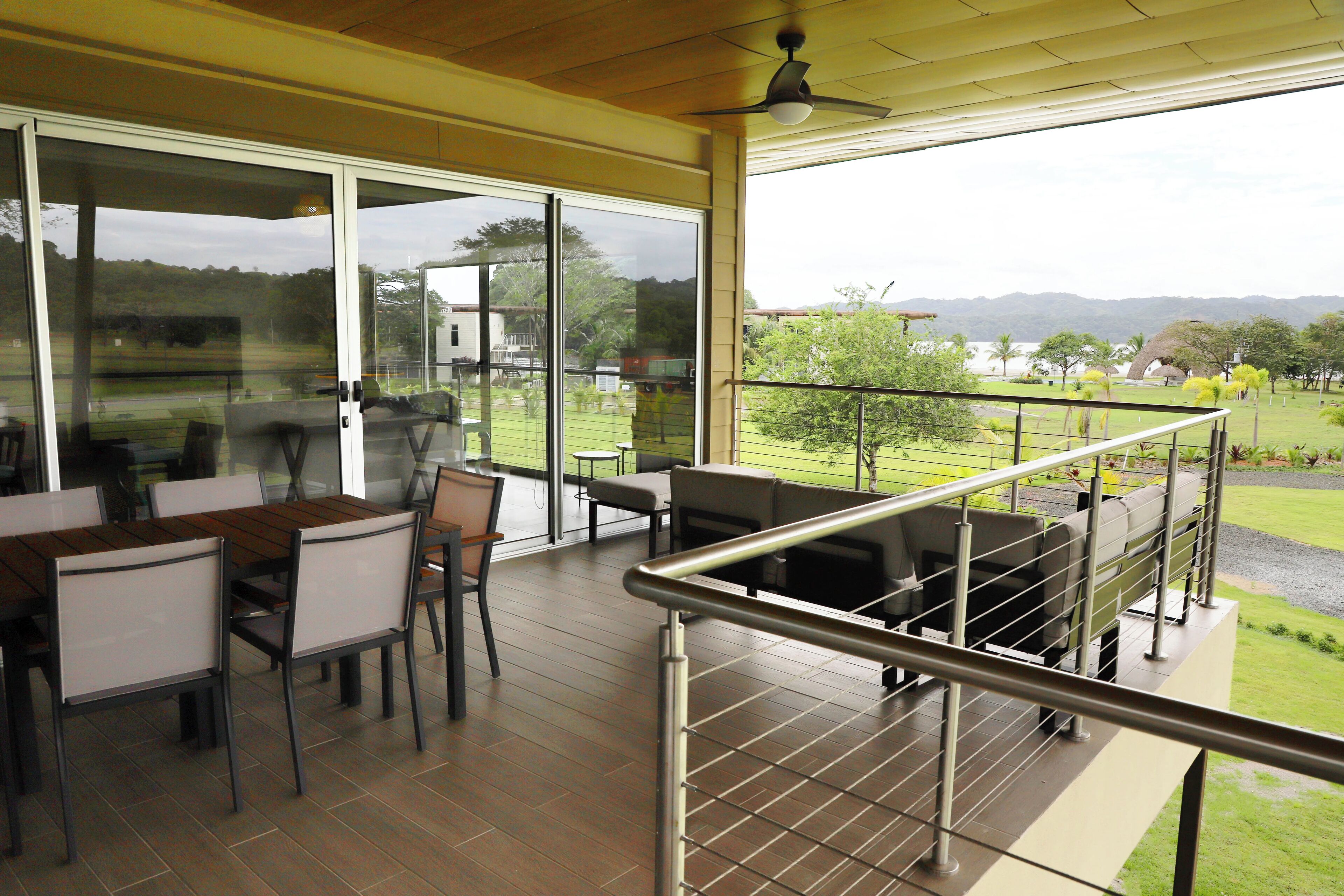 Un balcón amplio con vista a un campo de golf y colinas al lejano.