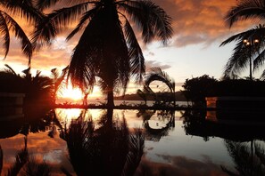 Una piscina al aire libre, sombrillas, sillones reclinables de piscina