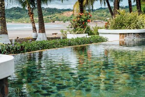 Una piscina al aire libre, sombrillas, sillones reclinables de piscina