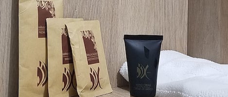 A wooden shelf with three brown paper bags and a black tube of hand cream.
