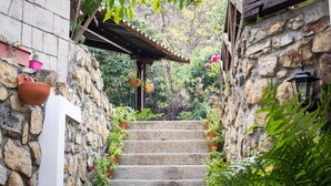 Una escalera de piedra con macetas y cestas colgantes de flores.