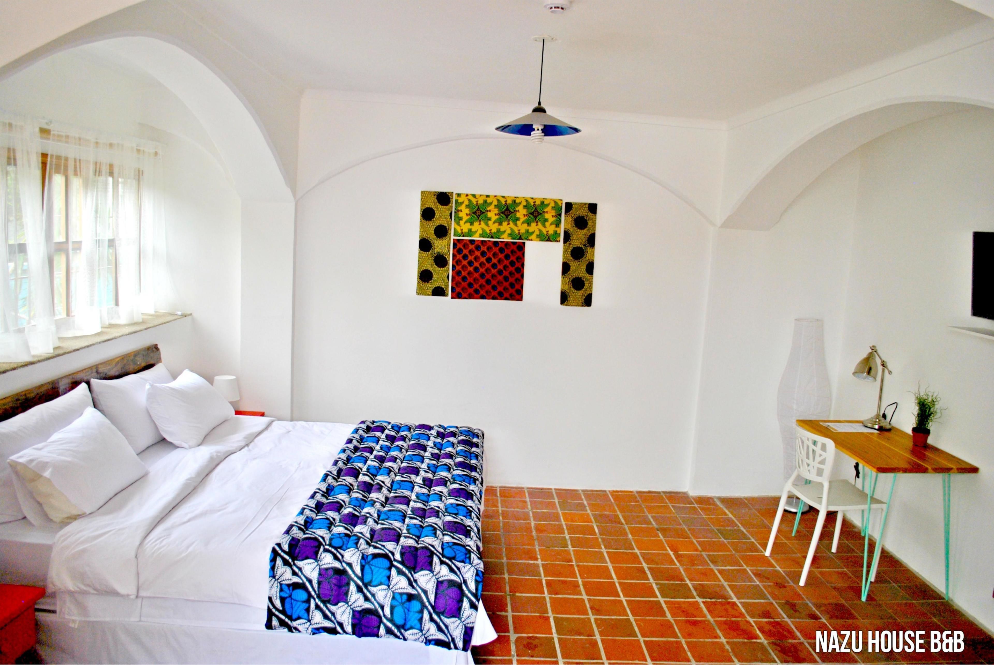 Ein Hotelzimmer mit einem Bett, einem Schreibtisch und einem kleinen Fenster.