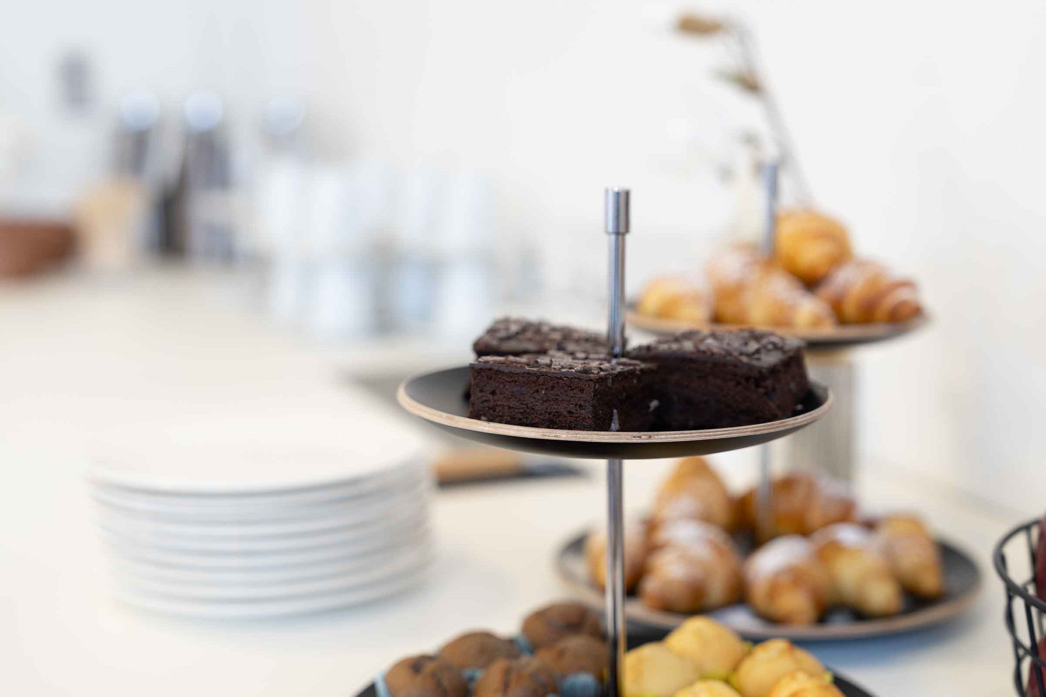 A dessert display with brownies and pastries on a table.