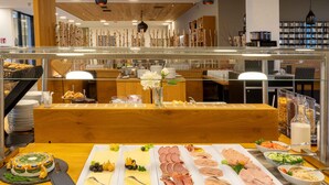 A buffet with various food items including a cake, cheeses, meats, and salads. - PLAZA INN Dachau - München (Dachau)