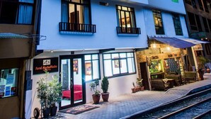 A multi-story hotel with a modern design, featuring balconies, large windows, and a restaurant on the ground floor. - Hotel Ferre Machu Picchu (Machu Picchu)
