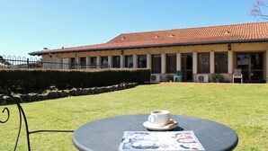 A building with a tiled roof and a lawn in front. - Banksia Motel Collie (Collie)