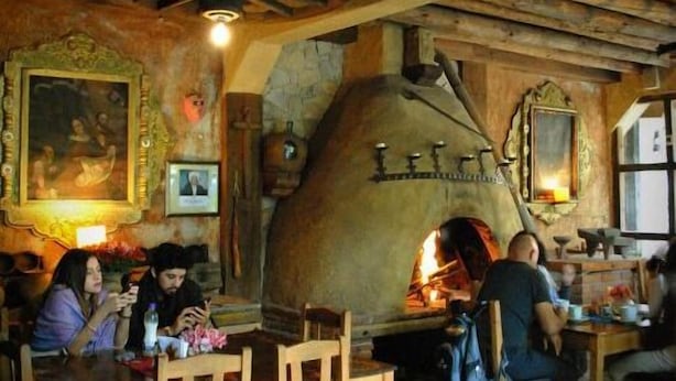 A rustic interior with stone walls, wooden furniture, and a traditional wood-fired oven. - Hotel Azulejos (San Cristóbal de las Casas)