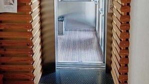 An elevator with a metallic interior, flanked by wooden paneling on the walls. - Hotel Azulejos (San Cristóbal de las Casas)