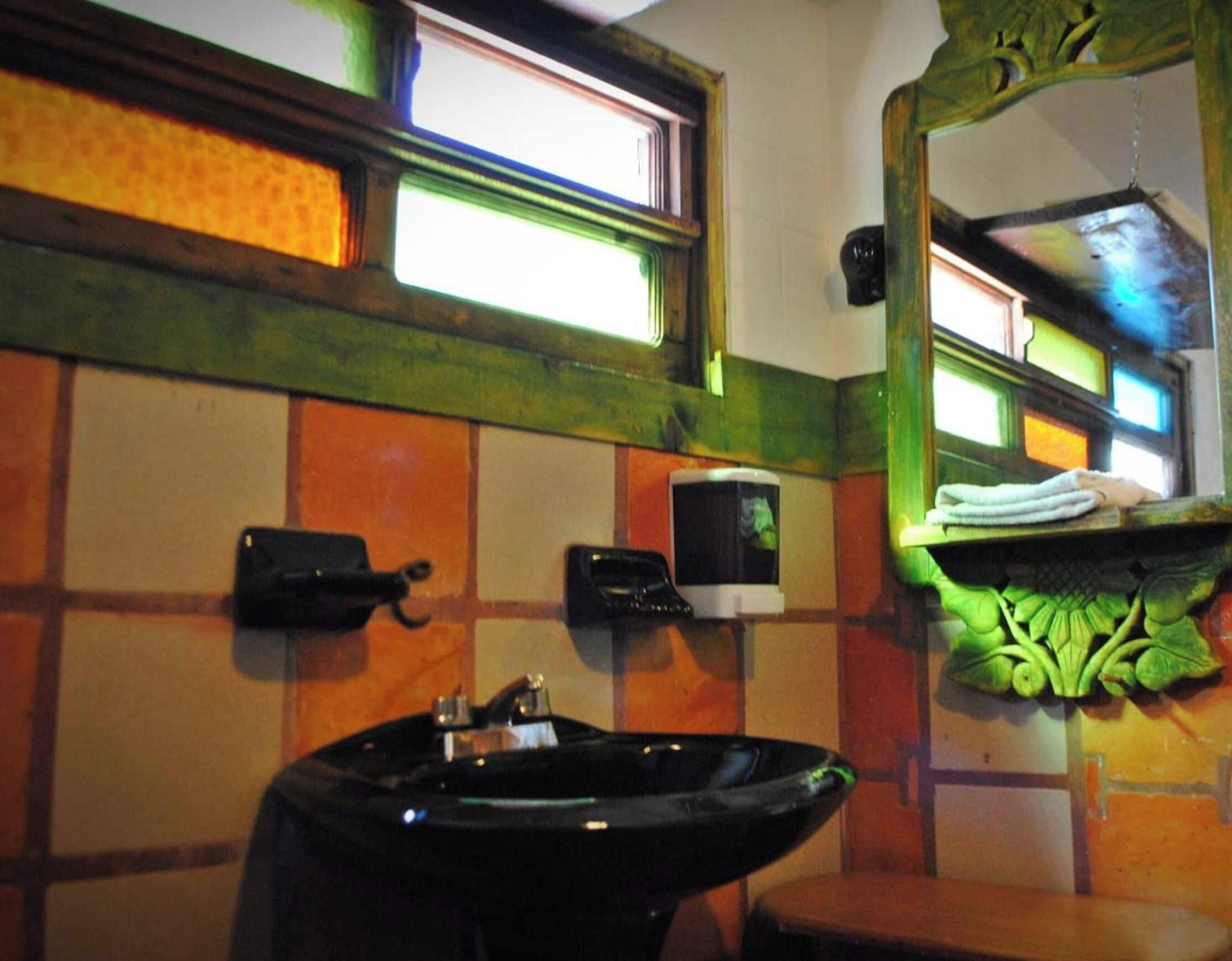 A bathroom with a sink, a mirror, and a window.