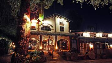Un edificio tradicional con fachada de piedra, ventanas arqueadas y un letrero que dice 'Hotel Hacette'.