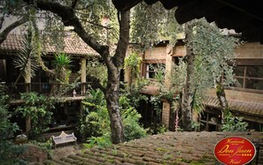 A courtyard with a traditional building, a bench, and a staircase. - Hotel Azulejos (San Cristóbal de las Casas)