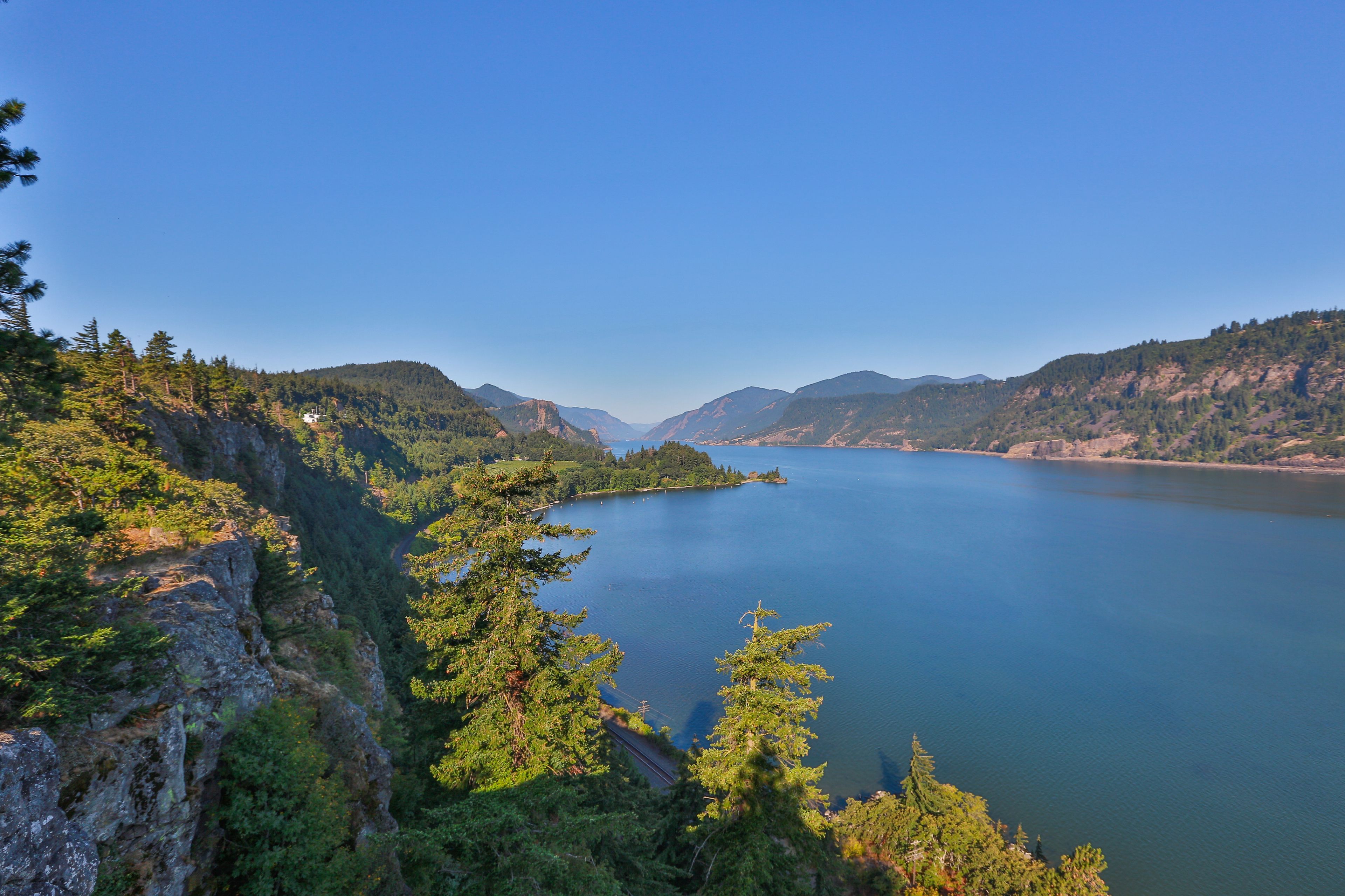 Una vista panorámica de un lago rodeado de montañas y densos bosques.