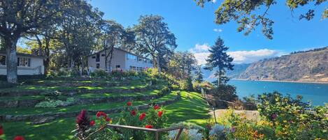 Una casa con jardín y vista al lago.