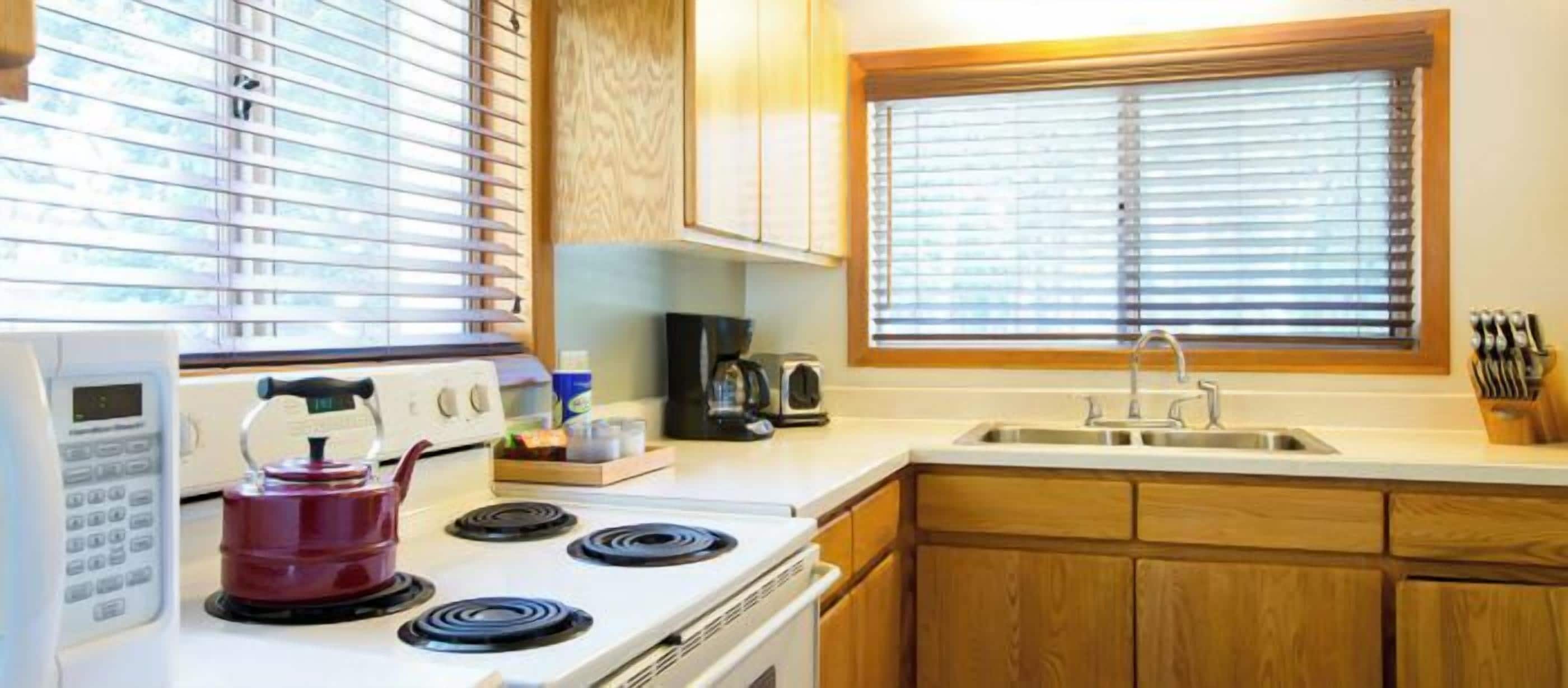 A kitchen with a stove, microwave, and sink.