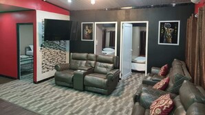 A modern living room with a leather sofa, a flat-screen TV, and a patterned carpet. - Al-Minhaj Service Apartments (Nadi)