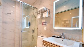 A modern bathroom with a glass-enclosed shower, a white sink, and a large mirror. - S79 Residences La Rose Spa (Ho Chi Minh City)