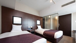 A hotel room with two beds, a large mirror, and a wardrobe.