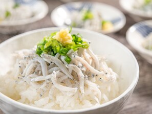 A bowl of rice topped with fish and green onions. - HOTEL MYSTAYS Shimizu (Shizuoka)