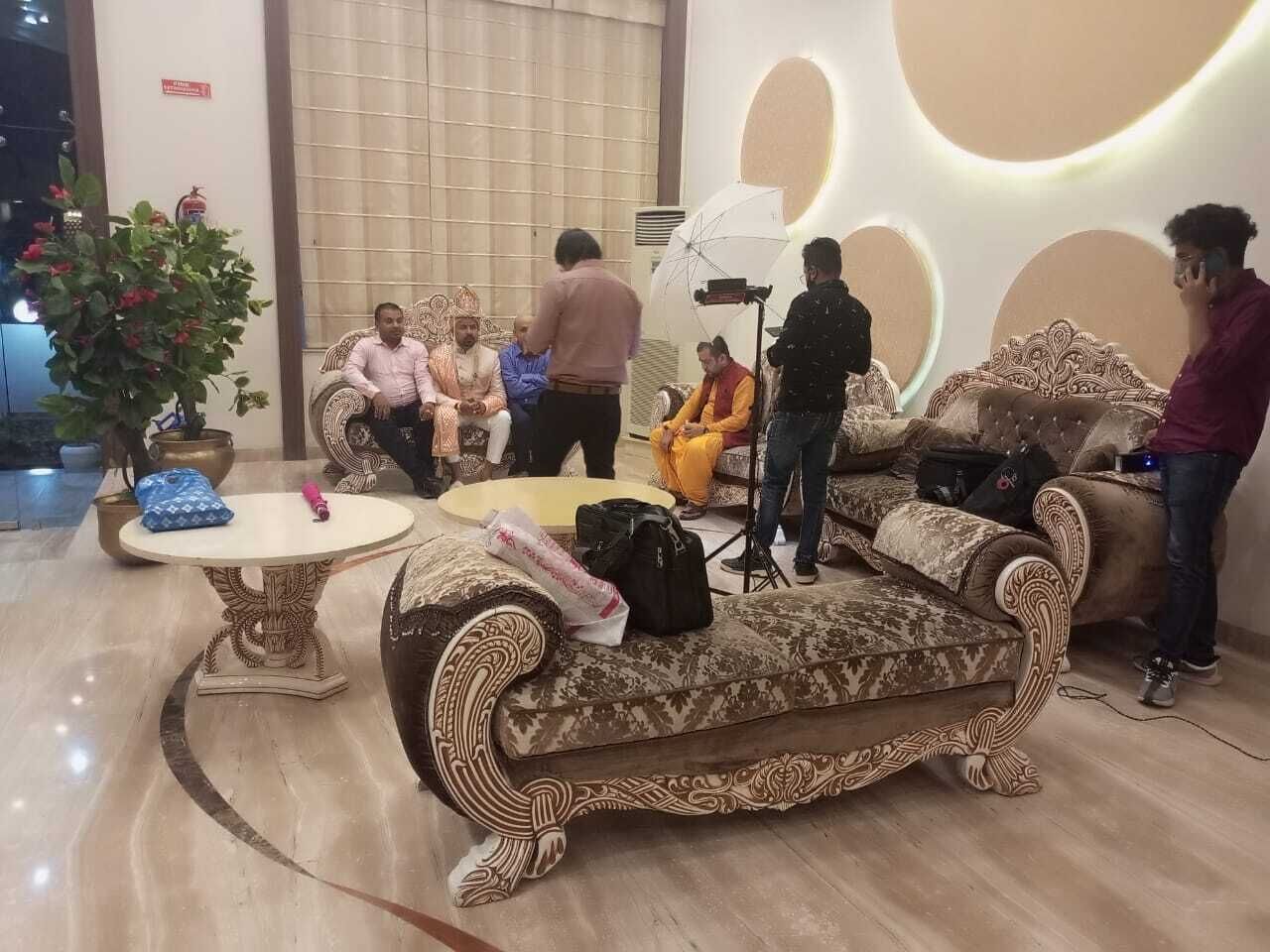 Un hall con un sofá estampado, una mesa redonda y una planta en maceta.