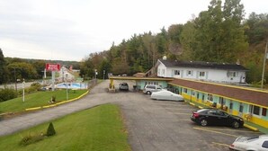A motel with a parking lot, a swimming pool, and a building with a yellow and white facade. - Westmount Motel (South-West Oxford)