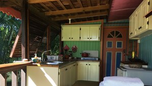 A compact kitchen with a wooden counter, a sink, and a stove. - Italian Guesthouse (Gros Islet)