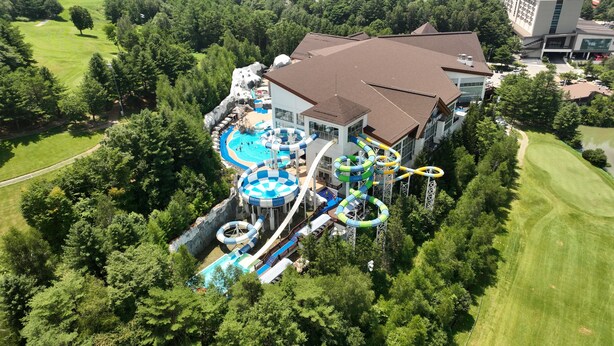 A large resort with a water park, including slides and pools, surrounded by lush greenery. - Mona Yongpyong Villa Condominium (Pyeongchang)
