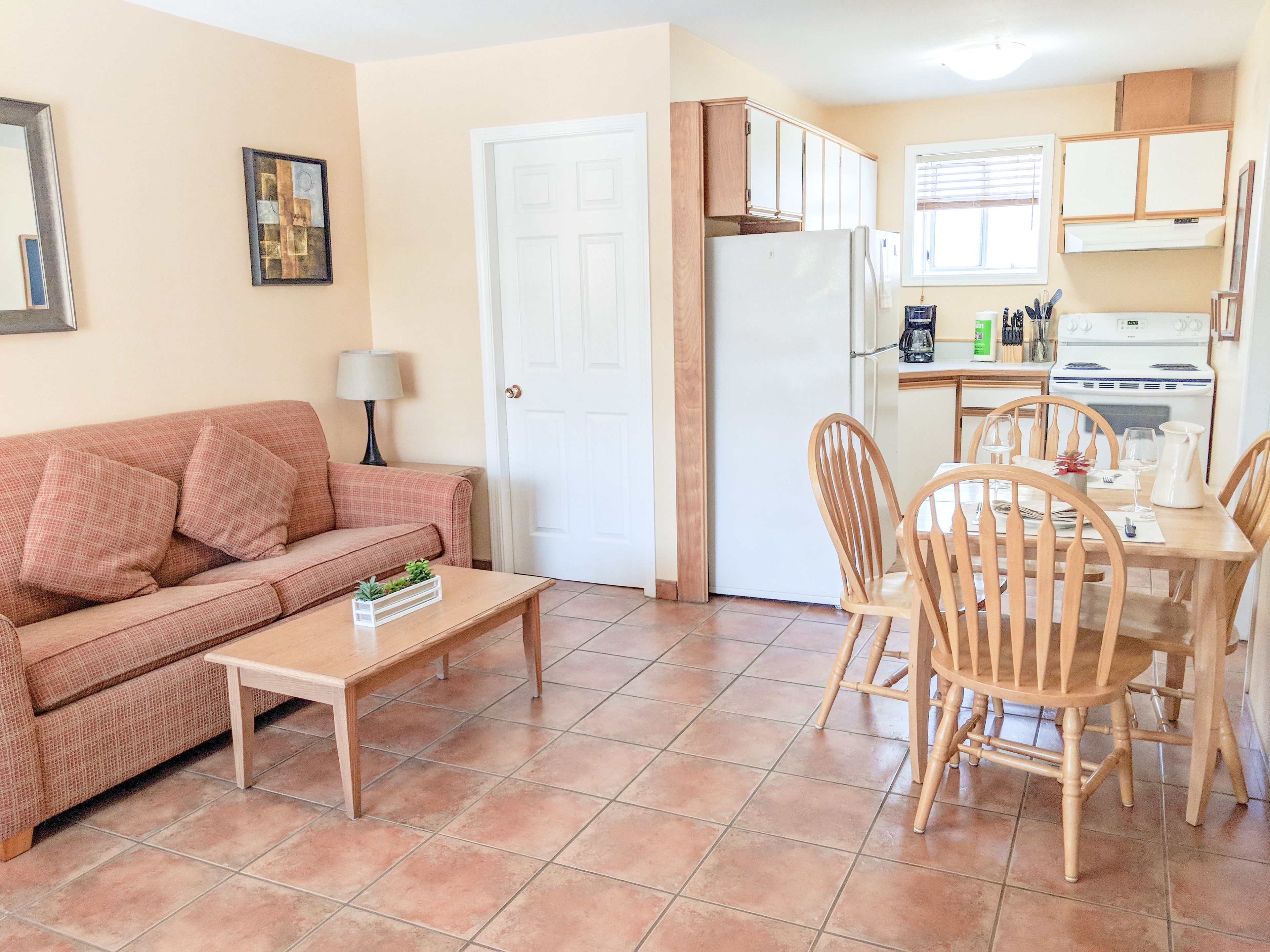 A compact living space with a kitchenette, a dining area, and a living room.